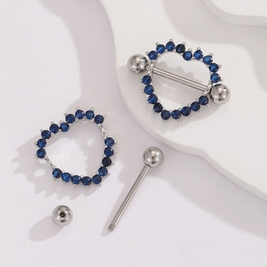 Detail of silver heart nipple ring with blue cubic zirconia and screw-on ball closure