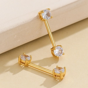 Golden stainless steel nipple rings with round cubic zirconia in a minimalist style