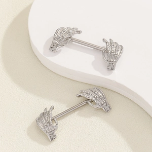 Detailed close-up of silver gothic skeleton hand nipple barbells with skeletal bone texture