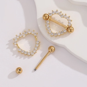 Macro detail of 18K gold plated heart nipple rings with zircon inlay on white stage