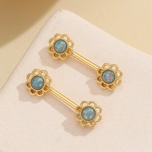 Detalle de joyas para el cuerpo de girasol doradas con opale azul sobre piedra