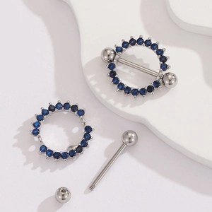 Macro shot of silver stainless steel nipple rings with inlaid dark blue zircon stones