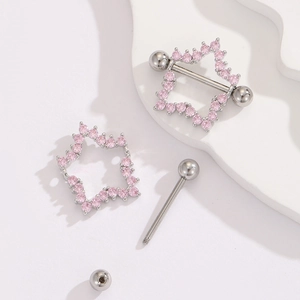 Macro view of pink star nipple rings with cubic zirconia on polished steel shield