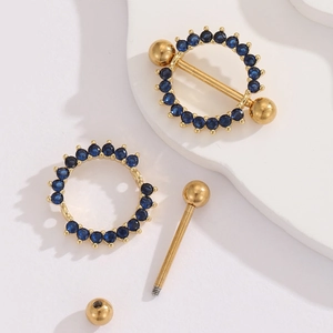 Detailed macro view of 18K gold-plated nipple rings with blue zircon set in stainless steel
