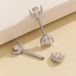 Macro detail of crescent moon nipple rings with pink opal and zircon in silver steel