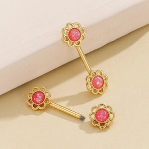 Foto macro de piercing para pezón dorado con flores y piedras rosas y detalle de rosca