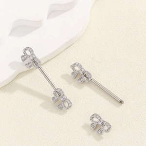 Detailed view of silver bow-knot piercing jewelry with shimmering white zircon stones