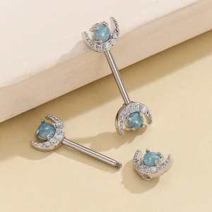 Macro view of moon-shaped nipple bars with blue opal and cubic zirconia inlay