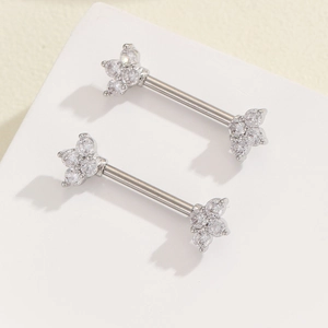 Detailed macro view of silver flower nipple rings set with clear zircon stones