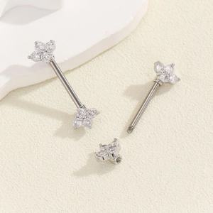 Detailed macro view of silver clover piercing stud with clear cubic zirconia and screw thread