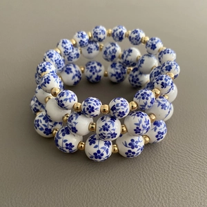 Set di bracciali in ceramica blu e bianca con perle metalliche dorate su pelle grigia