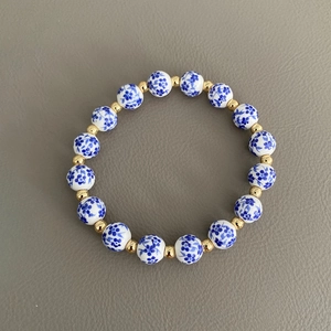 Dettaglio delle perle in ceramica blu e bianche e dei distanziatori dorati del bracciale