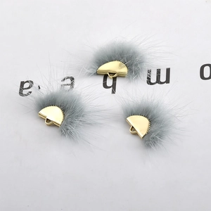 Close-up of grey mink fur fan charms with gold semicircular bases for DIY jewelry making