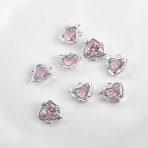 Detail of heart-shaped 14k gold plated charms with pink zircon and star accents