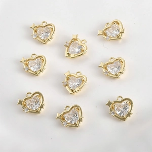 Detailed view of 14k gold plated heart pendants with clear cubic zirconia and star accents