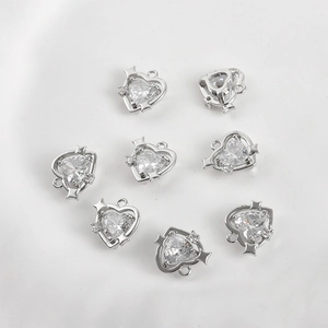 Detail of silver heart pendants with cubic zirconia and star charms for jewelry making