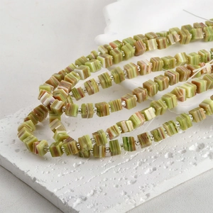 Macro detail of cube striped glass beads in green and brown for DIY jewelry making