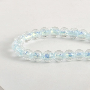 Dettaglio macro di perle traslucide iridescenti con glitter blu e viola per gioielli DIY