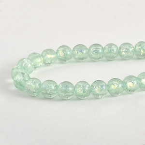 Dettaglio di perline in vetro cracklé verde chiaro iridescente per gioielli DIY