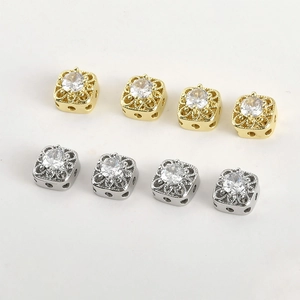 Macro shot of 14k gold-plated square filigree beads with sparkling cubic zirconia center