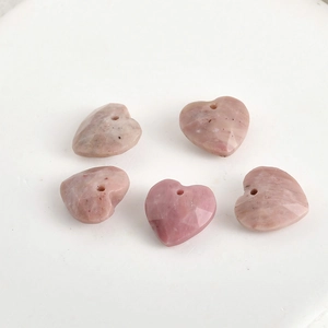 Detailed view of five 13mm faceted natural stone heart pendants with pre-drilled holes
