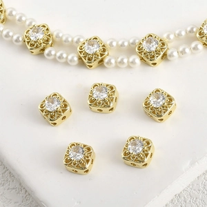 Macro detail of 14k gold plated square spacer bead with zircon set on pearl necklace