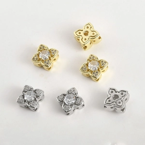 Detailed view of 14k gold and silver four-leaf flower spacer beads with micro-set zircon