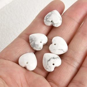 Macro detail of 13mm heart-shaped white howlite stone beads with grey veining for DIY