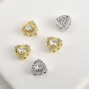 Detailed view of heart-shaped zircon charms with 14k gold plating and side hollow carvings
