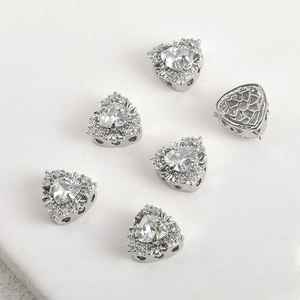 Macro detail of heart-shaped zircon charms showing fine pavé setting and hollow patterns
