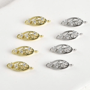 Dettaglio di ciondoli a foglia in oro 14k e argento con zirconi per bigiotteria
