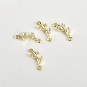 Dettaglio di connettori a foglia placcati in oro 14k con zirconi per la creazione di gioielli