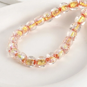 Macro shot of 8mm clear glass round beads with gold foil flakes for DIY jewelry making