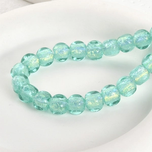 Macro shot of transparent mint green iridescent glass beads for DIY jewelry making