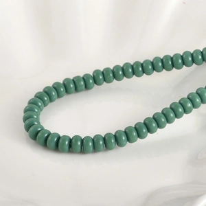 Vista macro de cuentas de vidrio abaco 5x8mm verde oscuro mate para joyería DIY