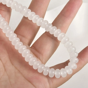 Detalle de cuentas de vidrio blanco 5x8mm tipo ábaco con efecto ojo de gato para bisutería DIY