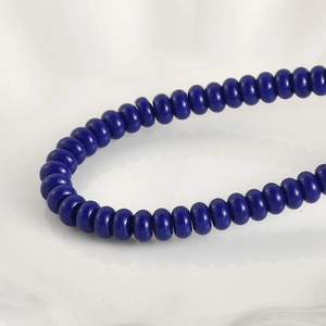 Vista macro de cuentas de vidrio azul oscuro pulido para la creación de pulseras y joyería DIY