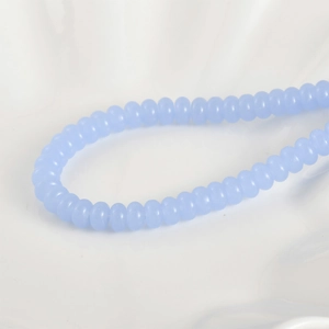 Detalle macro de cuentas de vidrio azul claro traslúcido para creación de joyería DIY