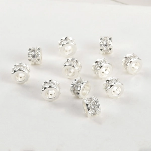 Macro shot of silver plated spacer beads with micro-paved cubic zirconia and faceted edges