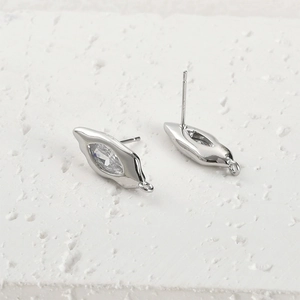Macro-opname van S925 zilveren marquise zirkoon oorknopjes op witte stenen textuur basis