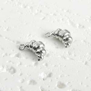 Macro detail of silver croissant-shaped 14k gold plated charms for jewelry making