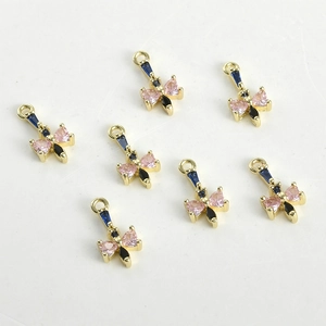 Dettaglio macro di ciondoli a farfalla placcati oro 14k con zirconi rosa per gioielli fai da te