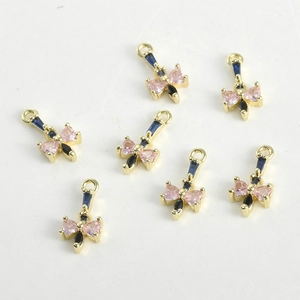 Dettaglio di ciondoli a fiocco placcati oro 14k con cristalli rosa per creazione di gioielli