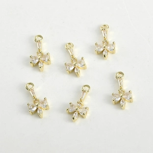 Dettaglio macro di ciondoli a fiocco placcati oro 14k con zirconi per gioielli fai-da-te
