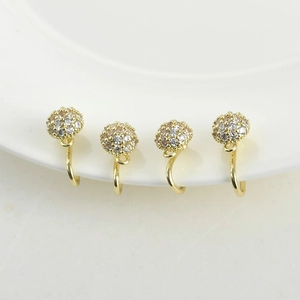 Vista macro di clip per orecchini placcati oro 14k con pavé di zirconi e anelli pendenti