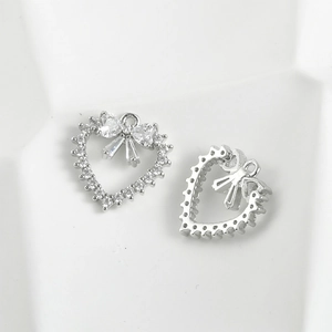 Macro detail of silver bow heart pendants with sparkling cubic zirconia for DIY jewelry