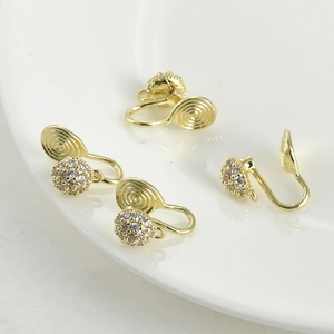 Dettaglio di quattro componenti per orecchini a clip placcati oro 14k per gioielli fai-da-te