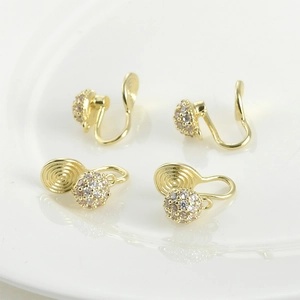 Dettaglio macro di clip per orecchie a U placcate oro 14k con pavé di zirconi bianchi scintillanti