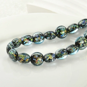 Macro detail of dark blue art glass beads with sparkling colorful foil inclusions