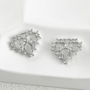 Detailed view of 14k plated heart pendant with bow design and shimmering zircon stones